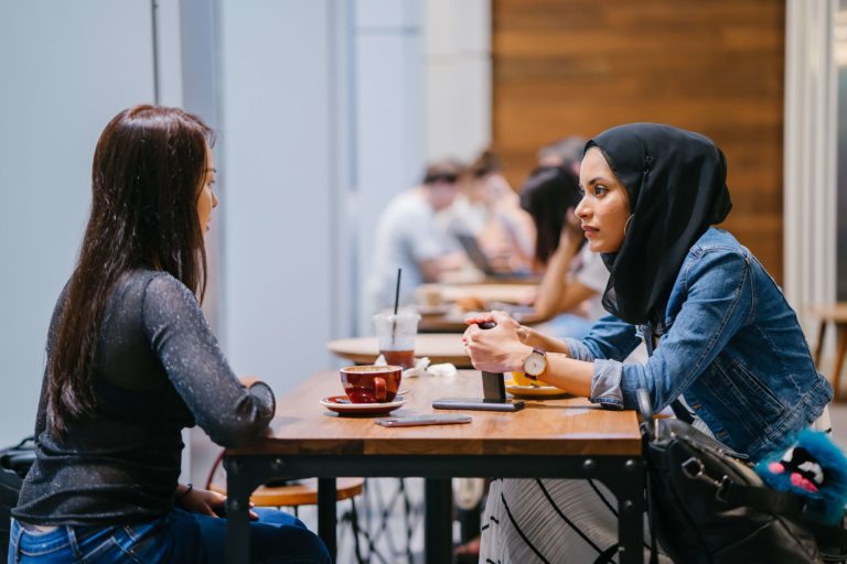 2 women having a conversation in a cafe