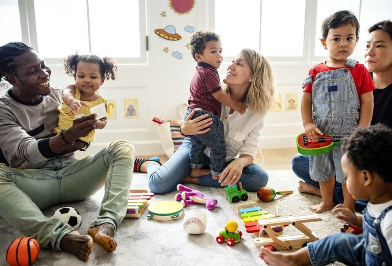 parents hug and play with their children in a kindergarten room