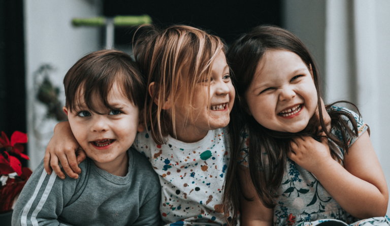 3 kids hugging and siling