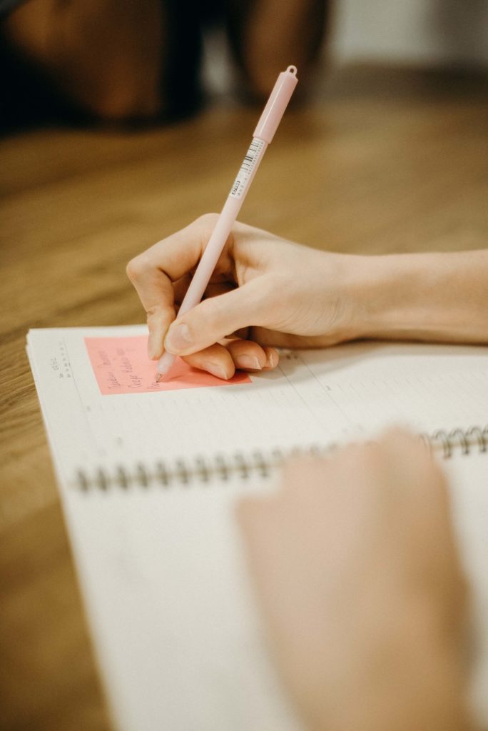 a hand writing in a notebook